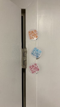 four qr code stickers on a white door