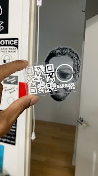 a person holding up a qr code in front of a door